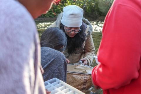 Natali Ramirez-Bullon helps a student check a net | FWS.gov
