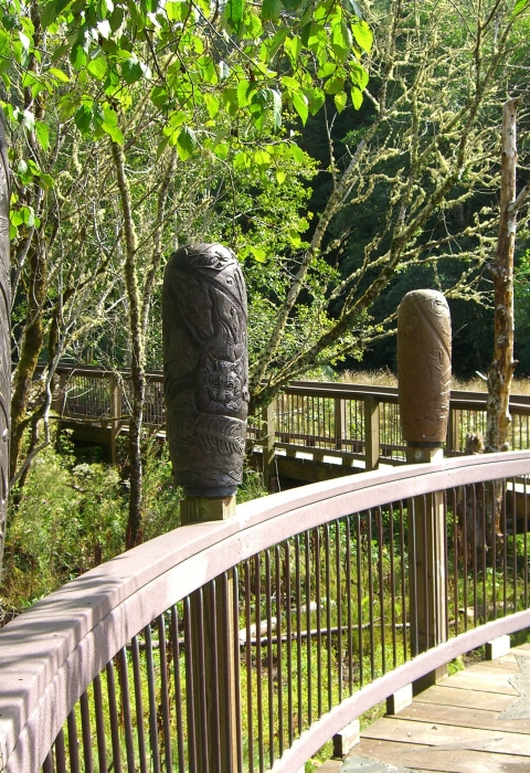 Carved posts along a boardwalk at Willapa National Wildlife Refuge show stages in the life cycle of a salmon.