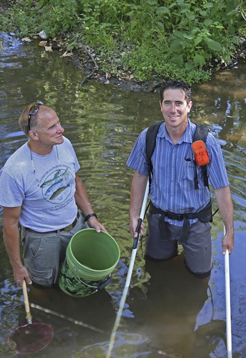 two men standing in a river