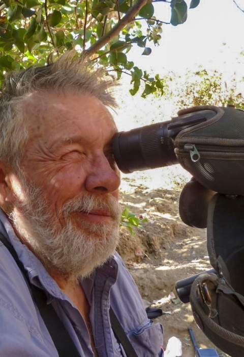 A man looking through a spotting scope