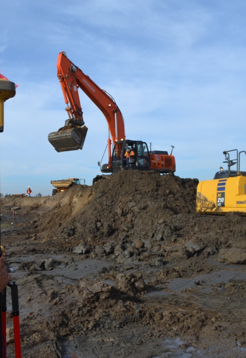 Contractor stands on the left viewing bulldozers level restoration site