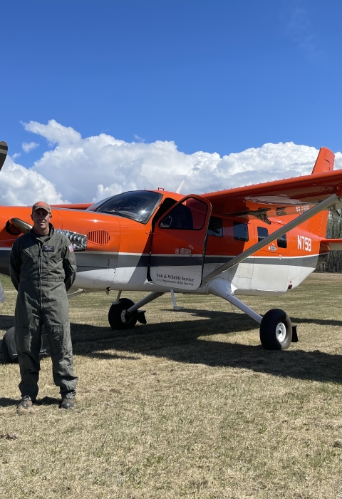 person stands in front of an airplane