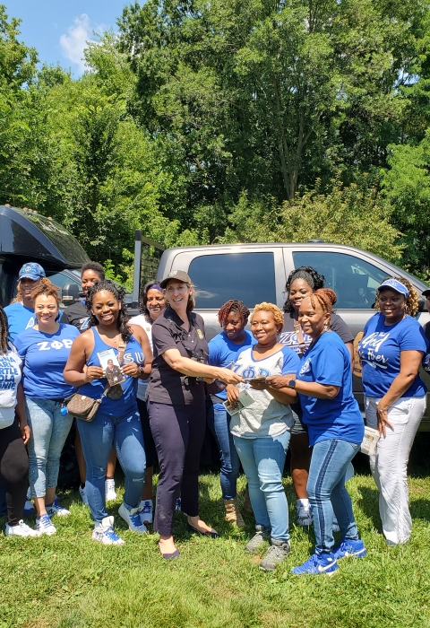 group stand outside, many wearing Zeta blue