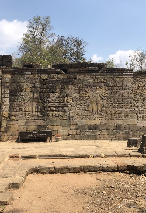 A stone wall with an open doorway and engraved images