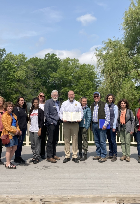 a group of community partners stand together with newly signed Urban Bird Treaty for the City of Hartford