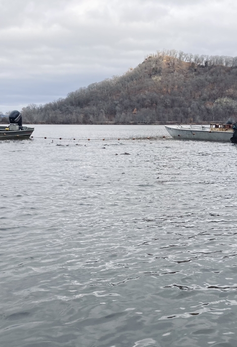 People on boats hold a seine net
