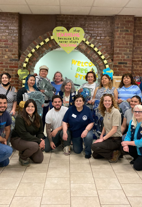 16 people pose together