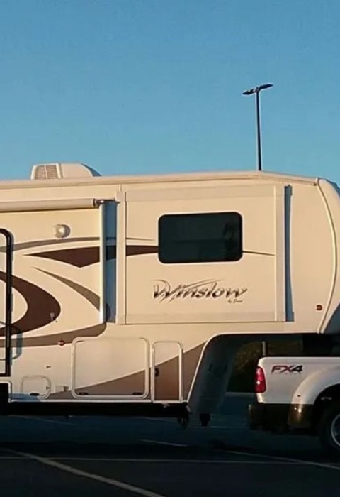 a large white truck pulls a long fifth wheel camper
