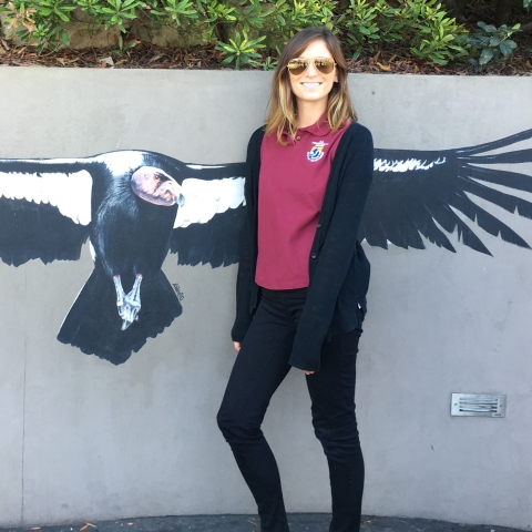 a woman standing by a picture of a large bird