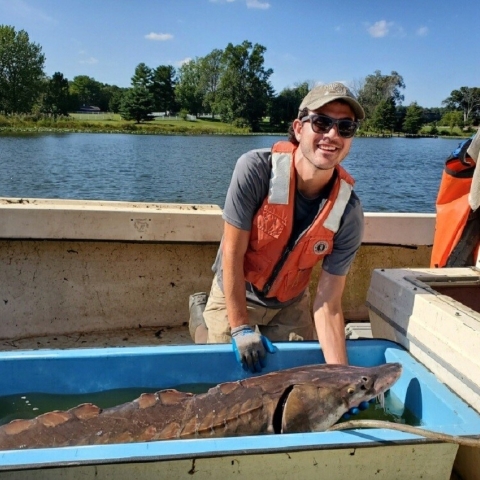 Fish and wildlife biologist Alex Vidal with a sturgeon