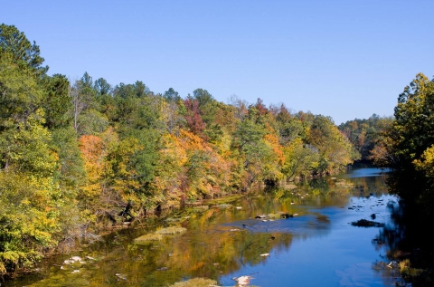 The Cahaba River bordered by trees in fall color. 