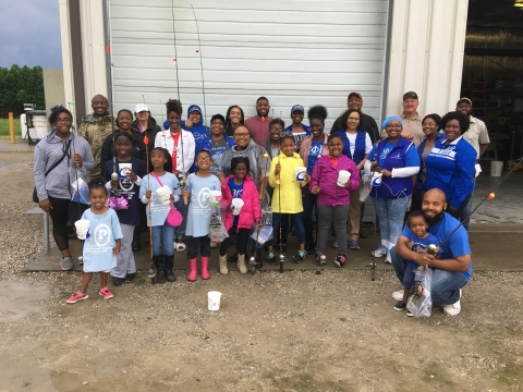 group photo of adults and kids with fishing rods