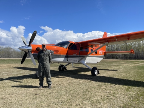 person stands in front of an airplane