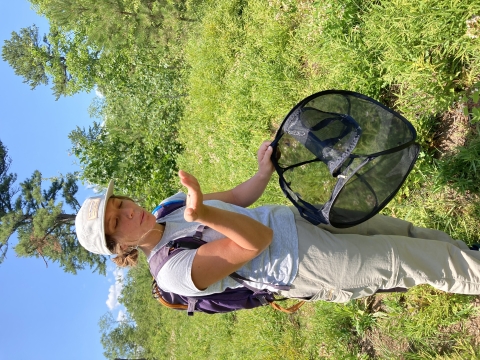 a young woman blows upon a tiny buttefly in the palm of her hand