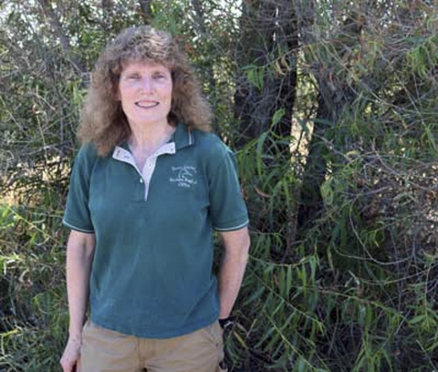 A woman in a green Ducks Unlimited shirt smiling for the camera.