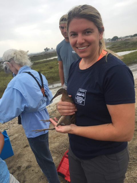 Sandra holds a rail at a marsh