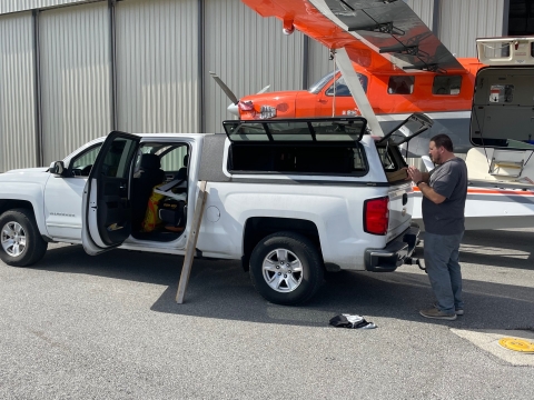 person stands at a truck to prepare equipment for airplane