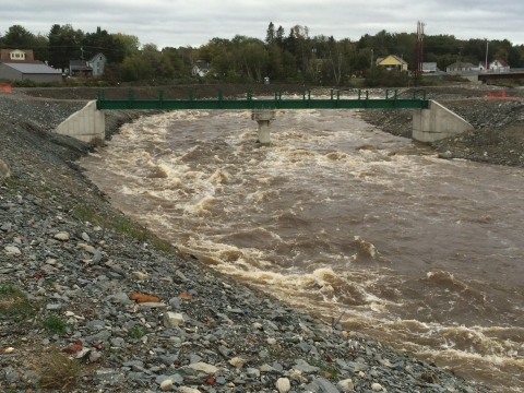 a high bridge lets rushing water course down a river 
