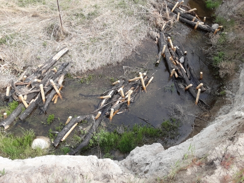 View of a stream with bundles of logs in it from above