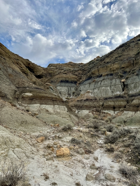 A badland formation under a cloudy sky.