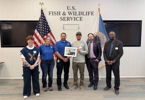 2024 National Junior Duck Stamp Art Contest judges holding the winning artwork