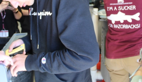 a boy handling a tagging apparatus with students in the background
