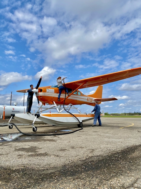 3 people inspecting an airplane