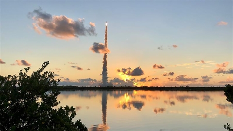 A rocket launches up to space in the golden dawn light from Cape Canaveral.