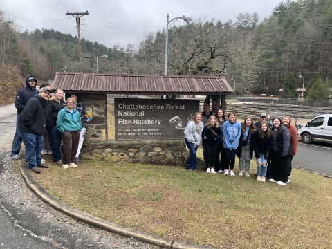 Iowa group poses in front of entrance sign