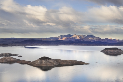 A lake with land masses and mountains behind it