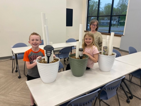 Three people smiling with their DIY frog hotels