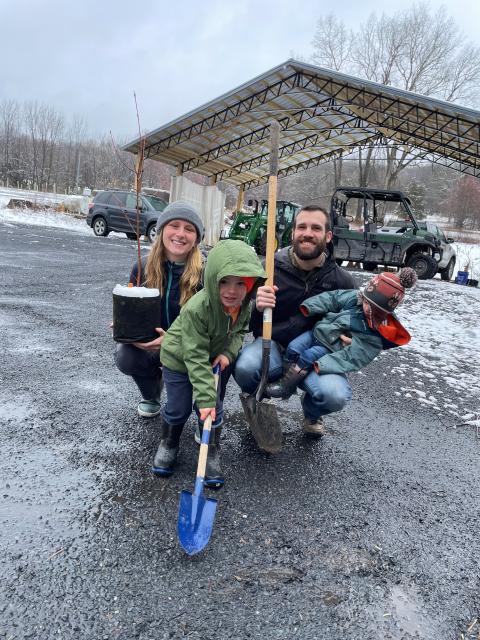Volunteer family poses with tree