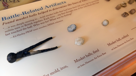 A museum exhibit panel showing artifacts from a Revolutionary War battle