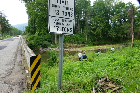 Line of people walking down to a small river