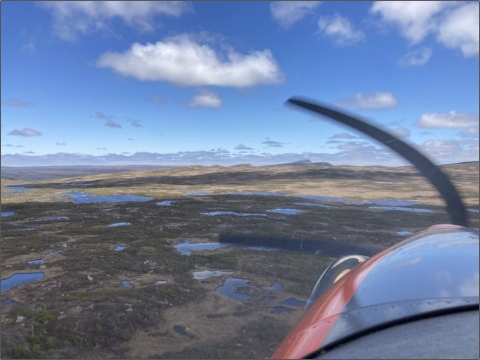 plane propeller over a landscape of wetlands and forests