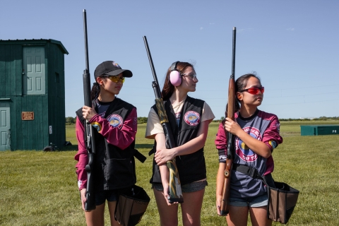 Three high school trap shooters pose at national championship