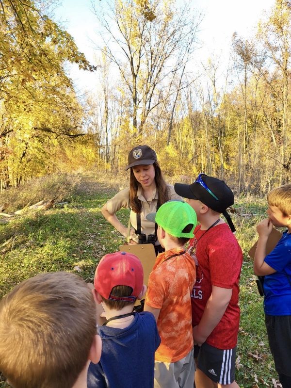 An education park ranger leading a guided hike with students.