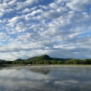 Looking at a hatchery pond with bluffs in the background on a beautiful cloudy day