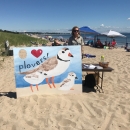 Intern conducts public outreach event at Rachel Carson NWR on a beach in Maine.