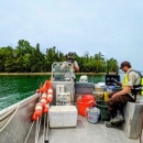 Two employees holding devices on a boat