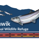 A blue sign with "Selawik National Wildlife Refuge" in text and an illustration of sheefish with a geometric design at the bottom