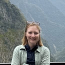 Olivia Williams with forested mountains in the background.