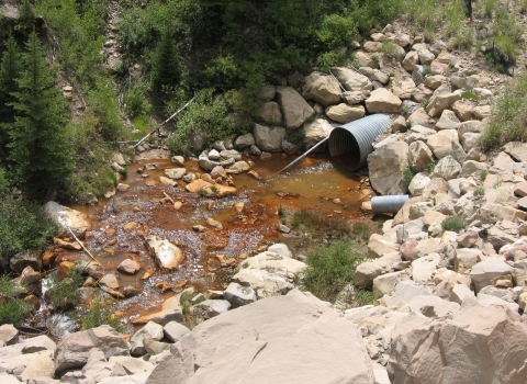 A stream with contaminants in the water near a mining operation.