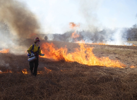 Female Firefighter holding a drop torch