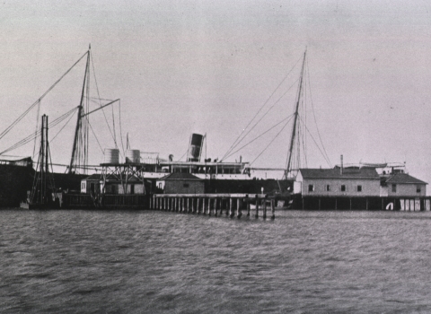 And old black and white photo of a ship and Blackbeard wharf.