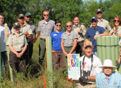 Friends of the Refuge Headwaters holding tree tubes outside.