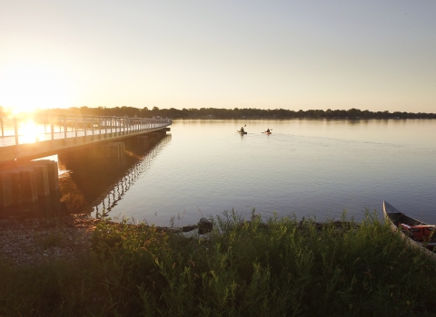 A rising sun shines on a new fishing pier at Detroit River International Wildlife Refuge.