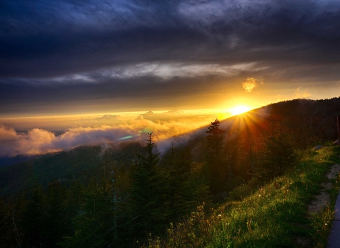 The rising sun paints a row of mountains beautiful shades of purple.