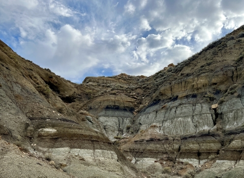 A badland formation under a cloudy sky.