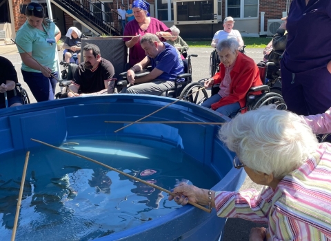 Elderly people fishing out of stock tank